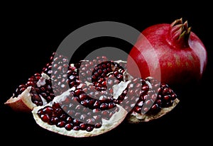 Ripe tasty pomegranate on a black background. isolate on a black background