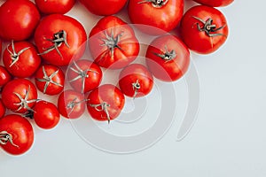 Ripe tomatoes of different size pattern on white background with copy space