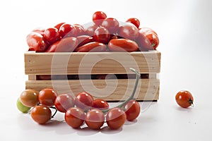 Ripe tomatoes on lie in a wooden box on a white background,,