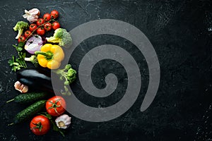 Ripe vegetables. Fresh vegetables on black stone background. Tropical fruits. Top view.