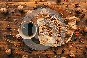 Ripe walnut fruit and coffee cup on table, top view