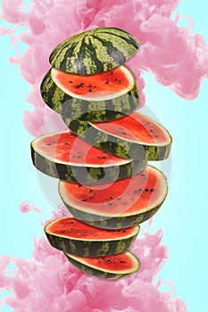 Ripe watermelon cut into pieces flying in the air, with a pink paint splash