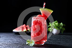 Ripe watermelon noisette balls with soda in glass on dark background. Refreshing summer drink photo