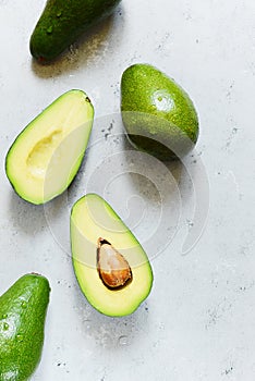 Ripe whole green avocado on a gray background. Flat lay. Food concept. Top view. Green avocadoes pattern