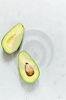 Ripe whole green avocado on a gray background. Flat lay. Food concept. Top view. Green avocadoes pattern