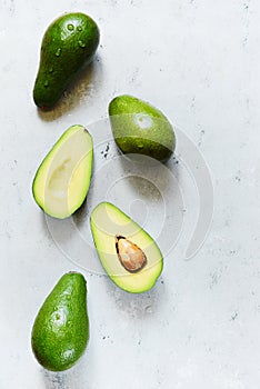 Ripe whole green avocado on a gray background. Flat lay. Food concept. Top view. Green avocadoes pattern
