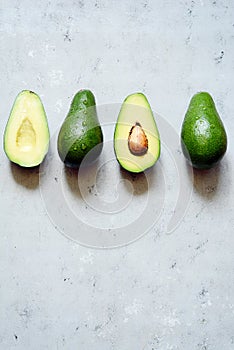 Ripe whole green avocado on a gray background. Flat lay. Food concept. Top view. Green avocadoes pattern