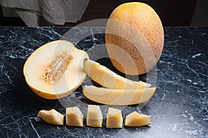 Ripe whole and half honeydew melon fruit at summer time. Sliced ripe juicy melon fruit