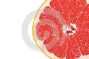Ripe, yellow grapefruit cut in half, resting on a white plate