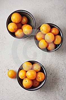 Ripe yellow mirabelle plums in bowls