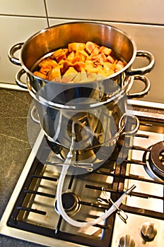 Ripe yellow and orange quinces in a big premium steel pot, a juice extractor, to cook some delicious juice