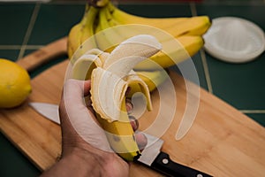 Peeled banana in a man`s hand