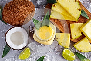 Ripe Yellow Pineapple, coconut, Smoothie with slices of Lime and ice. concept healthy food.