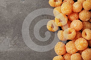 Ripe yellow raspberries on a marble background