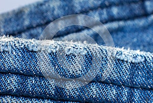Ripped blue hipster jeans material. Destroyed denim Cloth texture. Close up