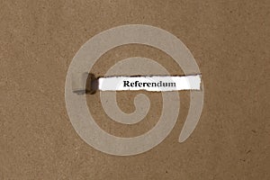 Ripped brown manilla envelope revealing the word referendum on white paper