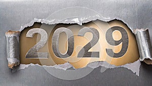 Ripped metallic paper revealling the year 2029 written in silver numbers on a golden background