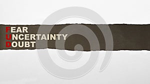 Ripped paper with \'Fear Uncertainty Doubt\' text