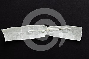 Ripped up piece of masking tape with copy space on black background