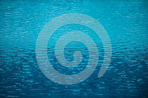 Ripped water in swimming pool. Surface of blue swimming pool, background of water.