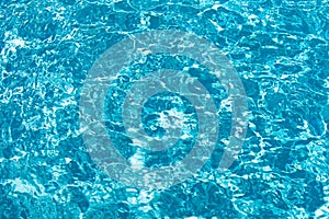 Ripped water in swimming pool. Surface of blue swimming pool, background of water.