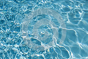 Ripped water in swimming pool. Surface of blue swimming pool, background of water.