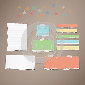 Ripped white and colorful note, notebook, copybook paper strips stuck with sticky tape, stars on brown background.