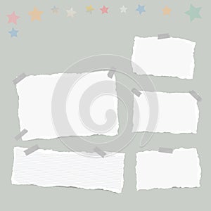 Ripped white note, notebook, copybook paper sheets, stars, stuck with sticky tape on gray background.