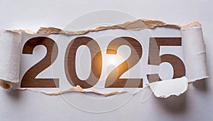 Ripped white paper revealling the year 2025 written in brown numbers on a white background