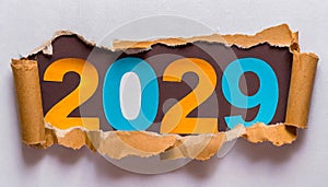 Ripped white paper revealling the year 2029 written in blue and orange letters on a white background.