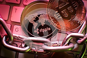 Ripple cryptocurrency coin on a laptop keyboard in a red colors . Falling market. Financial crisis.