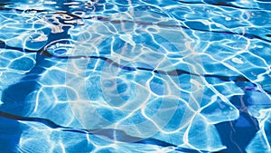 Ripple Water in swimming pool with sun reflection. Summer day at swimming pool. Background and texture concept.