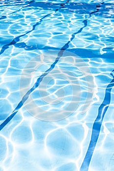 Ripple Water in swimming pool with sun reflection. Summer day at swimming pool. Background and texture concept.Vertical.