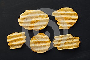 Rippled potato chips on black