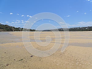 Rippled sand and meandering tide pools on the Bushmans River at low tide.