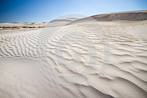 Rippled white sand dunes with coloured minerals