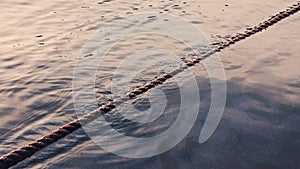 Ripples sea waves as water texture background and anchor rope