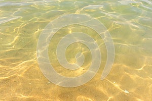 Ripples of water waves reflecting texture on a sandy beach bottom