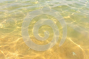 Ripples of water waves reflecting texture on a sandy beach bottom