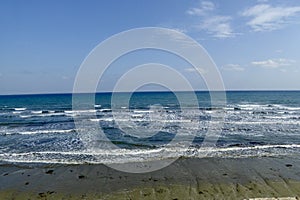 Rippling sea on the shore with blue sky