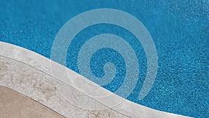 Rippling water surface in swimming pool. Top view. Summer, vacation, resort background