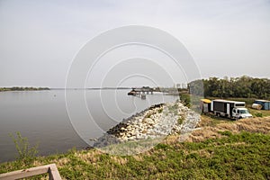 The rippling waters of the Savannah River with large rocks along the banks and lush green trees and plants at Old Fort Jackson in