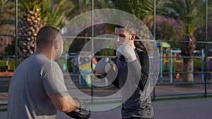 Rise and Box: Guy's Morning Shadowboxing Session on Palm-Adorned Basketball Court
