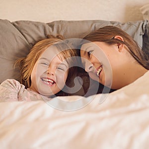 Rise and shine. a mother and her little girl lying in bed together at home.