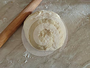 Risen or Proved Yeast Dough with Rolling Pin top view. Dough and Flour.