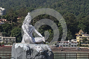 Statue of Shiva, Hindu idol near Ganges River water, Rishikesh, India. The first Hindu God Shiva. Sacred places for pilgrims