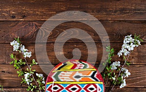 Rishtan Uzbek national plate and blooming cherry flowers on wooden background