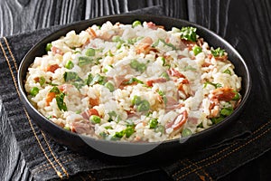 Risi e Bisi Arborio rice with green peas and prosciutto close-up on a plate. horizontal