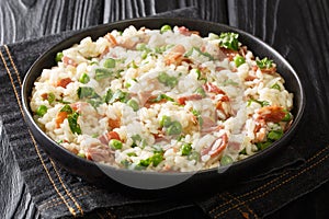 Risi e Bisi Arborio rice with green peas and prosciutto close-up on a plate. horizontal photo