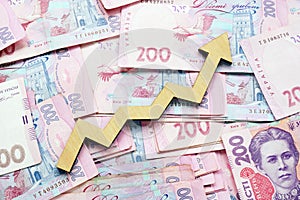 Rising arrow and Ukrainian hryvnia. Economic growth and money exchange